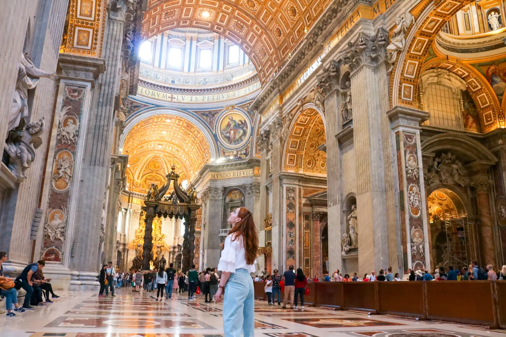 Visitors standing in quiet awe beneath the Sistine Chapel ceiling